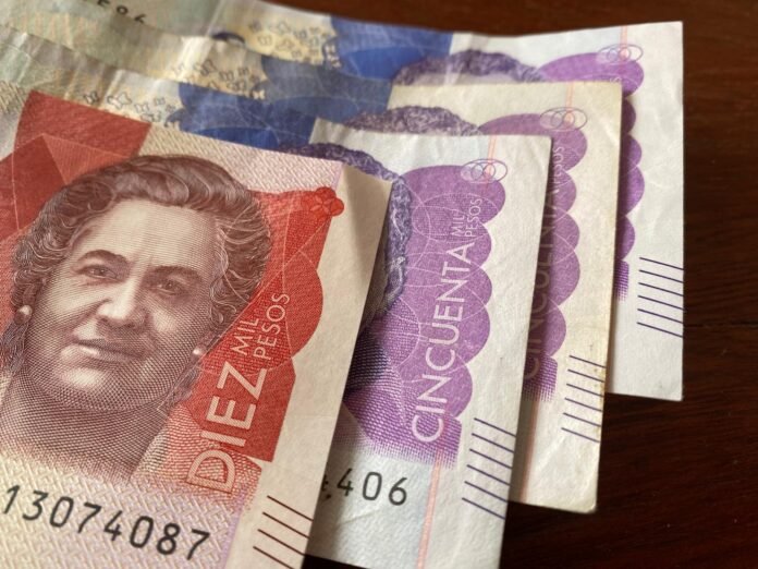 Cuáles son los aumentos del salario mínimo en Colombia este año 20 moneda colombiana sobre fondo de billetes